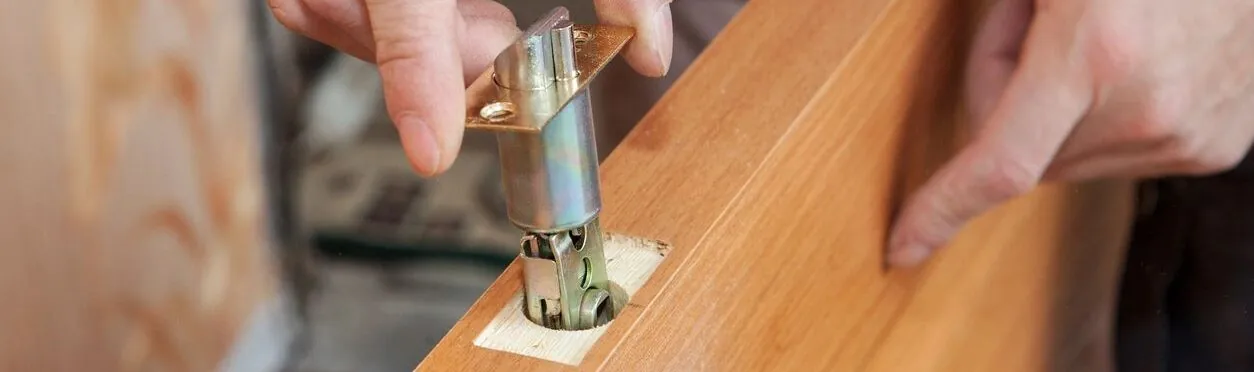 Door hardware being fitted to a wooden door