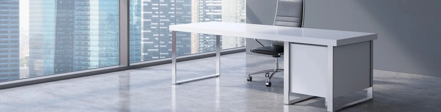 Office desk and chair beside large windows