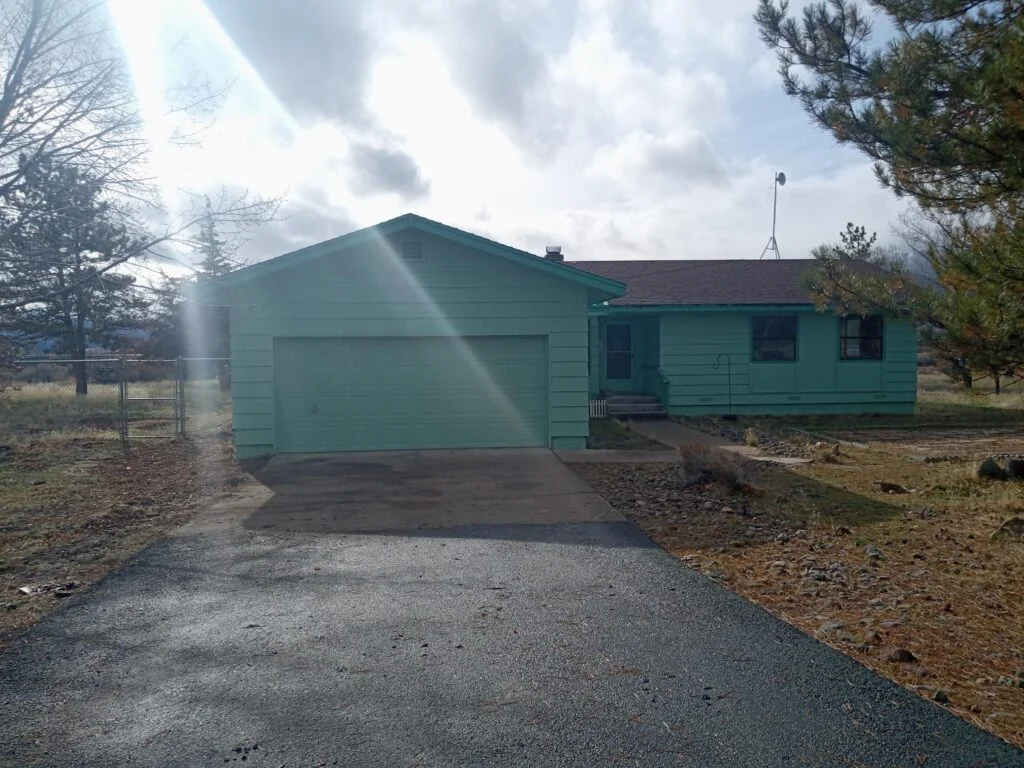 Single-story home with an attached garage and gravel driveway