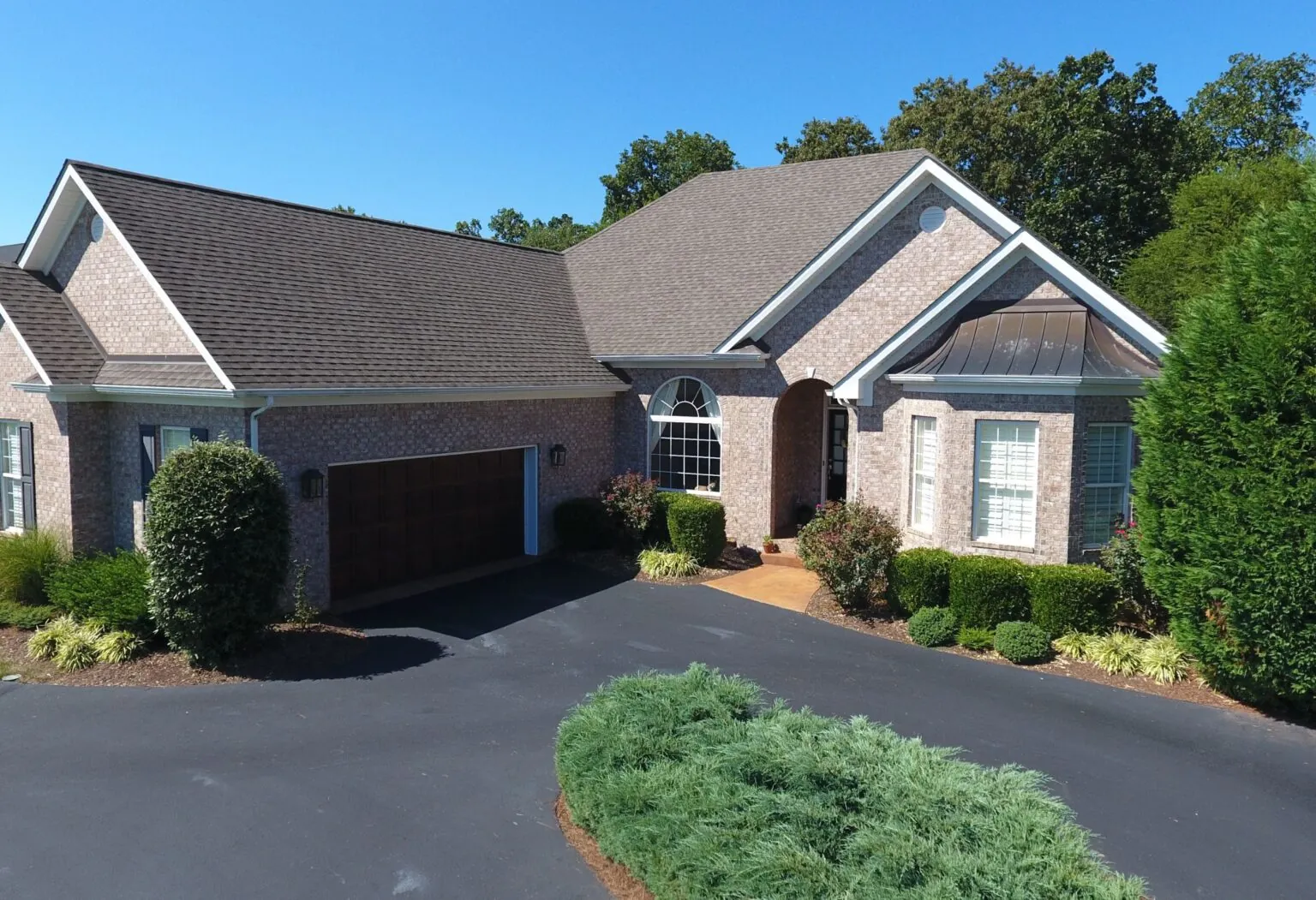 Maintained brick home with a landscaped front yard and driveway
